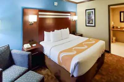 a hotel room with a large bed and a chair at Quality Inn & Suites Quakertown-Allentown in Quakertown