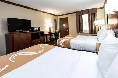 a hotel room with two beds and a flat screen tv at Quality Inn & Suites Quakertown-Allentown in Quakertown