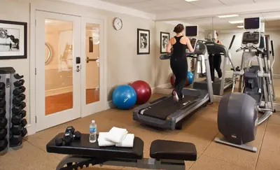 a woman exercising on a treadmill in a gym at Chestnut Hill Hotel in Philadelphia