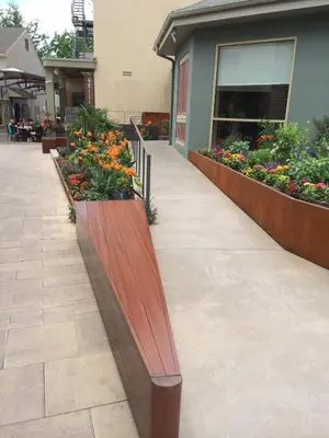 a wooden bench in front of a building with flowers at Chestnut Hill Hotel in Philadelphia