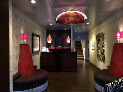 a lobby with a waiting area with red chairs and a chandelier at Chestnut Hill Hotel in Philadelphia