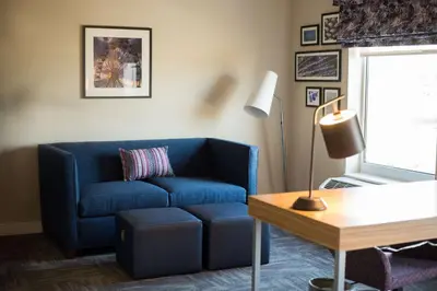 a living room with a blue couch and a lamp at Hampton Inn & Suites Warrington Horsham in Warrington
