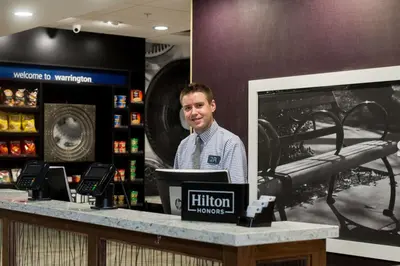 a man standing behind a counter in a store at Hampton Inn & Suites Warrington Horsham in Warrington