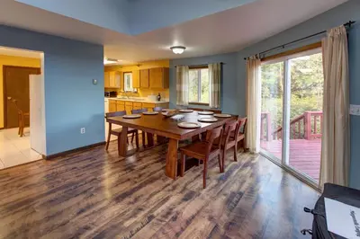 a dining room with a wooden table and a kitchen at The Guest House in Margaretville