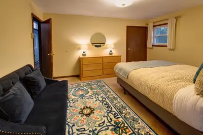a bedroom with a bed and a couch at The Guest House in Margaretville