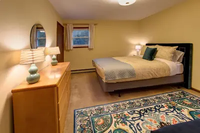 a bedroom with a bed and a dresser with two lamps at The Guest House in Margaretville