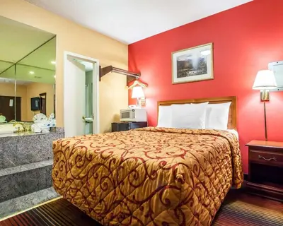a hotel room with a bed and a bathroom at Rodeway Inn Jersey City North in Jersey City