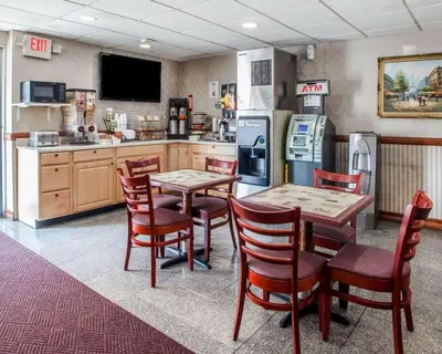 a kitchen with a table and chairs and a refrigerator at Rodeway Inn Jersey City North in Jersey City