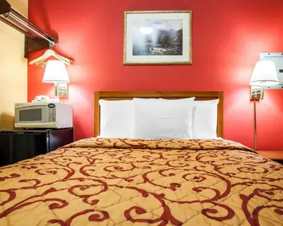 a bedroom with a bed with a red wall at Rodeway Inn Jersey City North in Jersey City