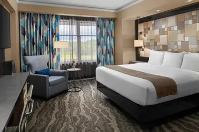 a hotel room with a bed and a chair at Mount Airy Casino Resort - Adults Only 21 Plus in Mount Pocono