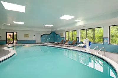 a pool in a hotel room with chairs and tables at Hampton Inn Danville in Danville