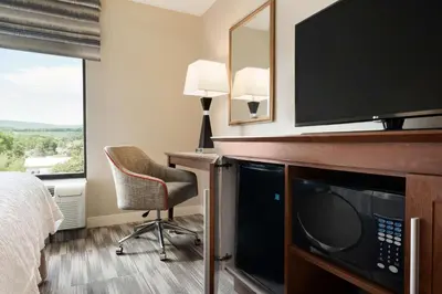 a hotel room with a bed and a desk with a tv at Hampton Inn Lehighton - Jim Thorpe in Lehighton