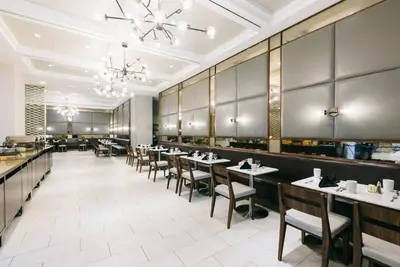 a dining room with tables and chairs at APA Hotel Woodbridge in Iselin