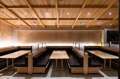 a dining room with wooden tables and benches at APA Hotel Woodbridge in Iselin