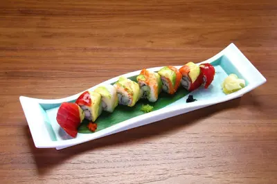 a plate of sushi on top of a wooden table at APA Hotel Woodbridge in Iselin
