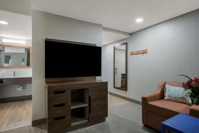 a living room with a flat screen tv on a wall at Hampton Inn Linden in Linden