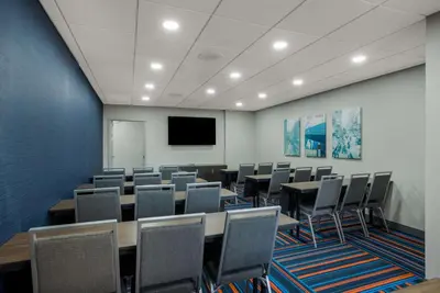 a conference room with tables and chairs and a tv at Hampton Inn Linden in Linden