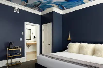 a bedroom with blue walls and a bed with a ceiling at The Franklin on Rittenhouse, A Boutique Hotel in Philadelphia