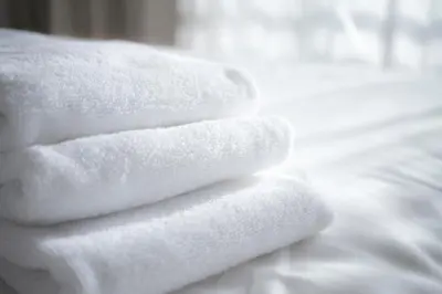 a stack of towels sitting on top of a bed at The Franklin on Rittenhouse, A Boutique Hotel in Philadelphia