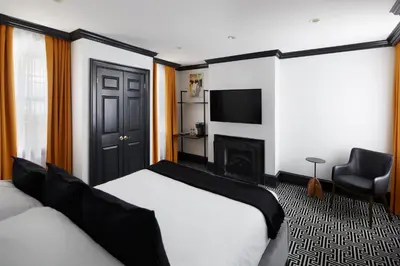 a hotel room with two beds and a fireplace at The Franklin on Rittenhouse, A Boutique Hotel in Philadelphia