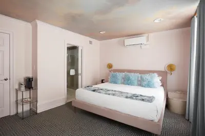 a bedroom with a large white bed with blue pillows at The Franklin on Rittenhouse, A Boutique Hotel in Philadelphia