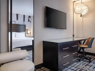 a hotel room with a desk and a bed and a television at Hilton New York Fashion District in New York