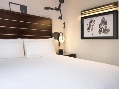 a bedroom with a large bed and a picture on the wall at Hilton New York Fashion District in New York