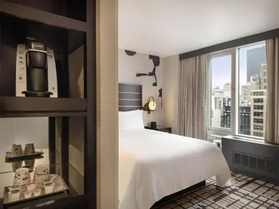 a hotel room with a bed and a window at Hilton New York Fashion District in New York