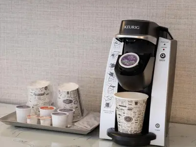 a coffee maker and some cups on a tray at Hilton New York Fashion District in New York