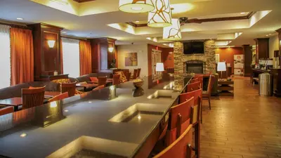 a restaurant with a bar with chairs and a fireplace at Hampton Inn Matamoras in Matamoras