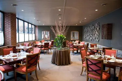 a dining room with tables and chairs and windows at Cork Factory Hotel in Lancaster
