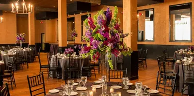 a room with tables and chairs with a vase of flowers at Cork Factory Hotel in Lancaster