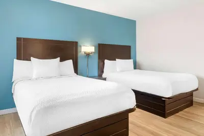 two beds in a hotel room with blue walls at Days Inn by Wyndham Wrightstown McGuire AFB Bordentown in Wrightstown