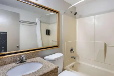 a bathroom with a sink and a toilet and a mirror at Days Inn by Wyndham Wrightstown McGuire AFB Bordentown in Wrightstown