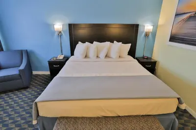 a hotel room with a large bed and a chair at Days Inn by Wyndham Wrightstown McGuire AFB Bordentown in Wrightstown