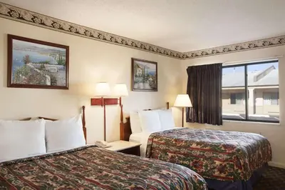 a hotel room with two beds and a window at Days Inn by Wyndham Wrightstown McGuire AFB Bordentown in Wrightstown