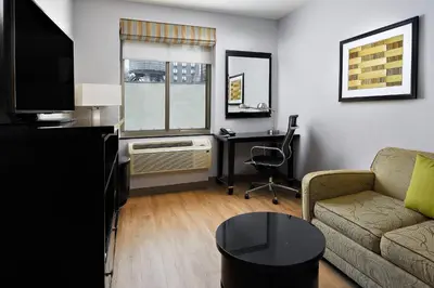 a living room with a couch and a desk with a computer at Fairfield Inn & Suites by Marriott New York Manhattan/Chelsea in New York