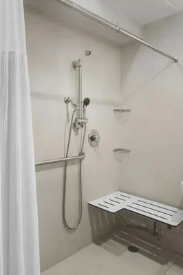 a bathroom with a shower with a bench in it at Fairfield Inn & Suites by Marriott New York Manhattan/Chelsea in New York