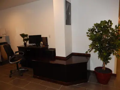 an office with a desk with a computer and two potted plants at Quality Inn near Sunset Park in Brooklyn