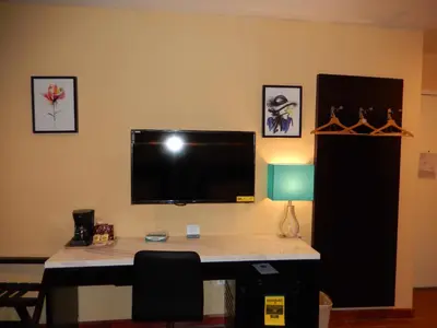 a desk with a television on a wall at Quality Inn near Sunset Park in Brooklyn