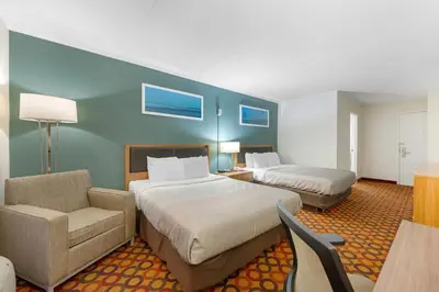 a hotel room with two beds and a chair at Quality Inn Enola - Harrisburg in Harrisburg