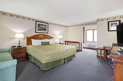 a hotel room with a bed and a television at Ramada by Wyndham Flemington in Flemington
