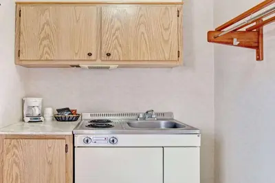 a small kitchen with a sink and a stove at Ramada by Wyndham Flemington in Flemington