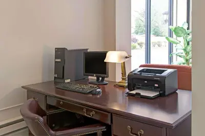 a desk with a computer and a printer on it at Ramada by Wyndham Flemington in Flemington