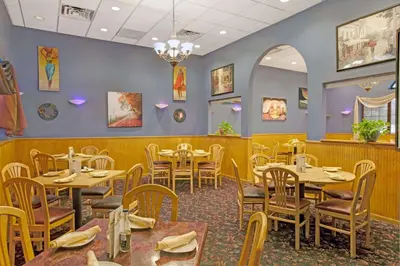 a dining room with tables and chairs in a restaurant at Ramada by Wyndham Flemington in Flemington
