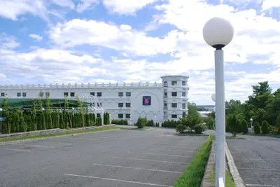 a white building with a street light in front of it at Raritan Hotel in Edison