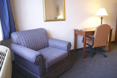 a room with a chair and a desk with a chair at Raritan Hotel in Edison