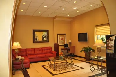 a living room with a red couch and a table at Raritan Hotel in Edison