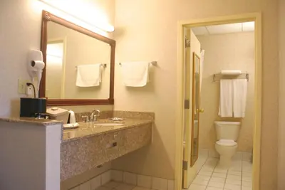 a hotel bathroom with a sink and a toilet at Raritan Hotel in Edison