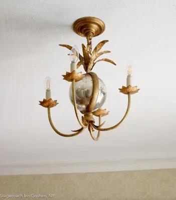a brass chandelier hanging from a ceiling at Stagecoach Inn in Goshen
